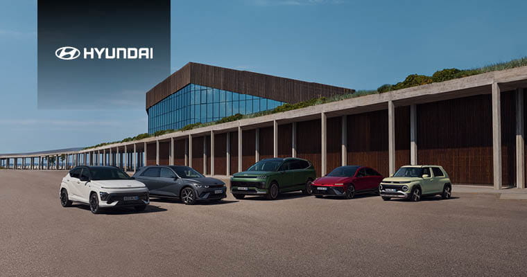 Fünf verschiedene Hyundai-Modelle stehen nebeneinander vor einem modernen Gebäude mit großer Glasfassade; im oberen linken Bereich ist das Hyundai-Logo mit Schriftzug.