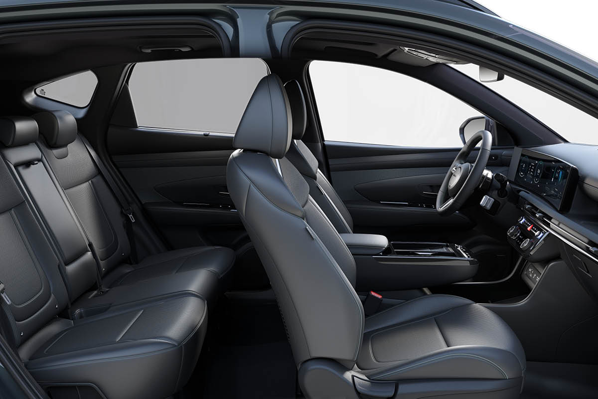 Seitlicher Blick in den Innenraum eines modernen Autos: vorne und hinten dunkelgraue Ledersitze, eine schlanke Mittelkonsole, digitales Cockpit und Multifunktionslenkrad. 